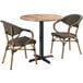 A Lancaster Table & Seating Yukon Oak table with two brown French Bistro arm chairs.