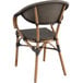 A Lancaster Table & Seating Excalibur Yukon Oak table with 2 brown arm chairs with black and brown cushions.