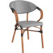 A black and white French bistro arm chair with wooden legs and a seat and backrest.