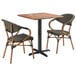 A Lancaster Table & Seating Yukon Oak table with 2 brown French bistro arm chairs.