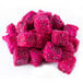 A pile of Pitaya Foods organic frozen pink dragon fruit cubes on a white surface.