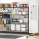 A Metro Super Erecta gray wire shelving unit in a school kitchen filled with food items.