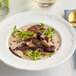 A white plate with a bowl of Dried Forest Blend Mushrooms.