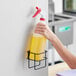 A hand holding a yellow Lavex spray bottle of liquid.