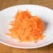 A plate of shredded carrots on a Robot Coupe 9/32" grating / shredding disc.