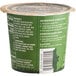 A green and white Kodiak Cakes oatmeal cup with text on it.