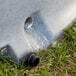 A water hose pouring into a concrete drain.