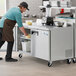 An aproned man using an Avantco worktop freezer in a professional kitchen.