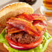 A close-up of a bacon sandwich on a table.