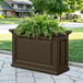 An espresso Mayne Nantucket trough planter on an outdoor table with plants in it.