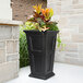 A Mayne Fairfield black rectangular planter with a green plant inside.