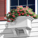 A white Mayne Yorkshire window box with pink flowers in it.