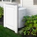 A white Mayne Nantucket privacy panel with a plant next to it.