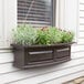 An espresso Mayne Nantucket window box with flowers on a window sill.