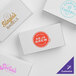 A group of white customizable candy boxes with a blue logo on one.