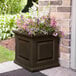 An espresso Mayne Nantucket planter with flowers in it.