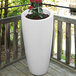 A white Mayne Modesto planter with a plant in it.