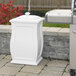 A white rectangular Mayne Mansfield storage bin next to a grill.