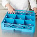 A person holding a blue Carlisle glass rack with clear glass inside.