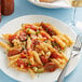 A plate of Barilla penne pasta with sauce and a fork.