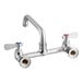 A chrome Regency wall mount faucet with silver and red and blue knobs.