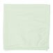 A green microfiber cloth folded on a white surface.