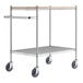 A Regency chrome utility cart with wooden shelves on black wheels.