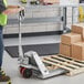 A man holding a Lavex stainless steel pallet jack.