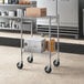 A Regency chrome utility cart with boxes on the shelves.