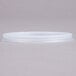 A translucent plastic lid with a straw slot on a gray surface.
