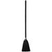 A black Rubbermaid Executive Series lobby broom with a wood handle.