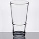 A close-up of a Libbey customizable mixing glass half full of liquid.