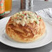 A bread bowl with food on top.