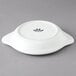 A white Tuxton round china shirred egg dish.