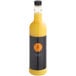 A yellow and black Twisted Alchemy Valencia Orange Juice bottle full of orange liquid.