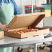 A woman holding a Choice corrugated catering box of pastries.