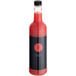 A bottle of Twisted Alchemy Cold-Pressed Watermelon Juice with a black and red label on a table in a cocktail bar.