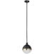 A black and brass Globe pendant light with white glass inside hanging in a restaurant.