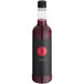 A close up of a black Twisted Alchemy Pomegranate Juice bottle with a red logo.