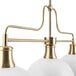A Globe Matte White and Matte Brass chandelier with white glass shades.