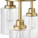 A Globe matte gold brass flush mount light fixture with clear glass shades.