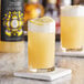 A glass of Twisted Alchemy lemon sour craft mixer with a lemon slice on top.