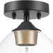 A Globe semi-flush mount ceiling light with a matte black and gold finish and clear glass globe.