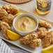 A plate of fried chicken with French's Honey Mustard Sauce on it.