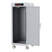 A large metal Metro C5 heated holding cabinet with solid doors and wheels.