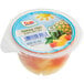 A Dole plastic container of tropical fruit with a lid.