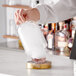 A bartender using a Flavour Blaster to pour liquid into a glass.