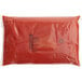 A red plastic bag with black text filled with red liquid.