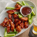 A plate of French's BBQ chicken wings and celery sticks.