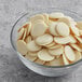 A bowl of Republica del Cacao white chocolate couverture discs.